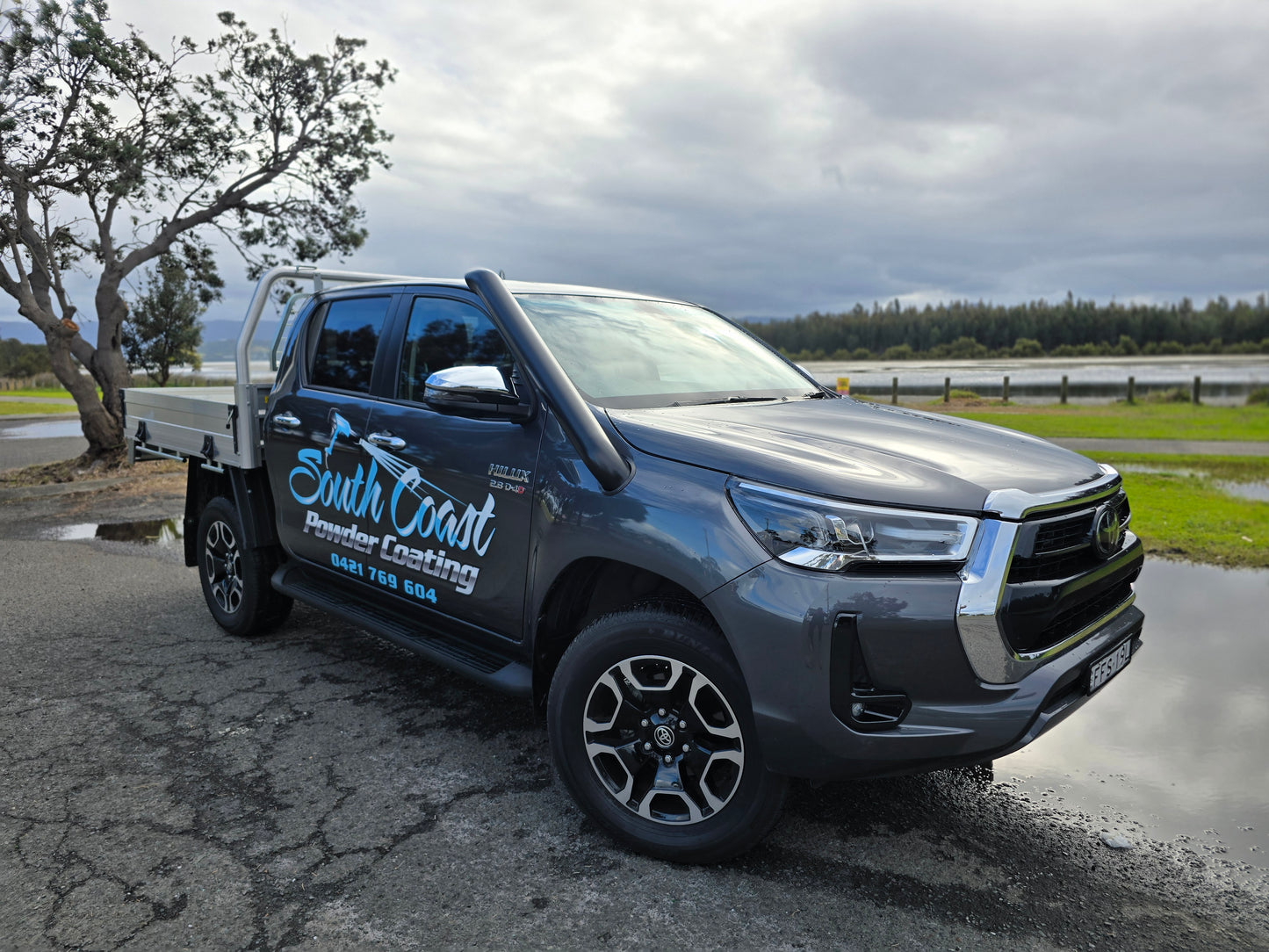 Show thumbnail preview
A gray pickup truck with South Coast Plumber & Roofing on the side is parked near a water body.