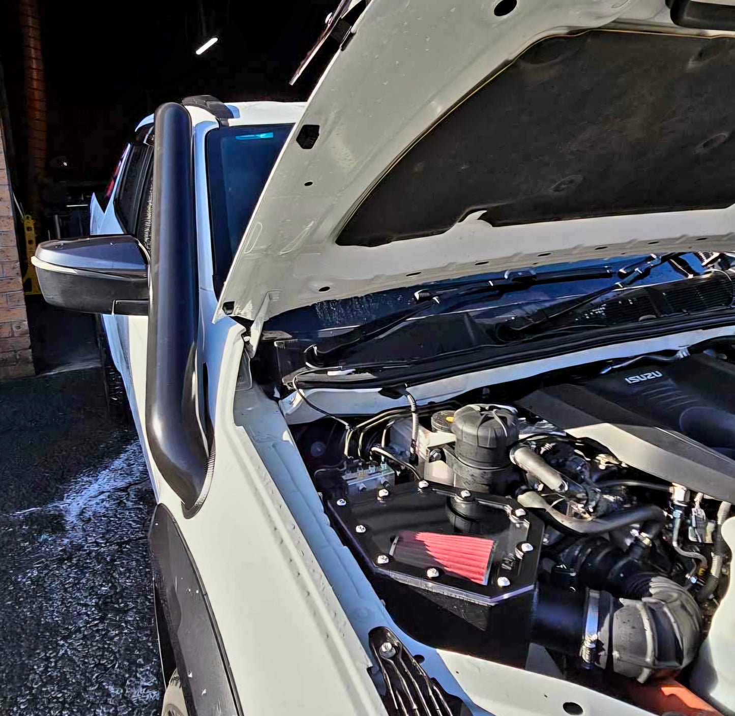 white vehicle with open hood showing engine
